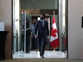 Justin Trudeau, Canada's prime minister, walks to a news conference in Ottawa. He is wearing a black face mask.