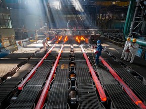 Workers make iron bars at a steel factory in China.