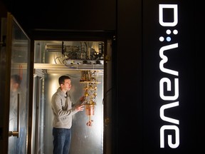 A worker checks the cryostat inside a D-Wave quantum computer.