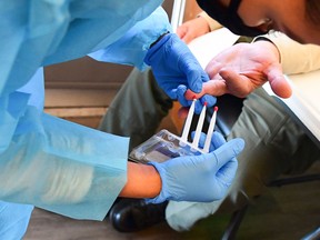A phlebotomist takes blood through a finger prick in California.
