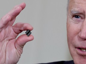 U.S. President Joe Biden holds a semiconductor chip as he speaks prior to signing an executive order, aimed at addressing a global semiconductor chip shortage, in February.