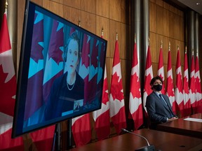 Prime Minister Justin Trudeau listens to Deputy Prime Minister and Minister of Finance Chrystia Freeland speak virtually during a news conference in Ottawa.