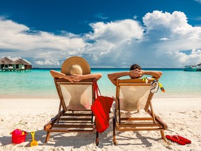 Couple in loungers on a tropical beach in the Maldives