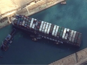his satellite imagery released by Maxar Technologies shows tug boats and dredgers attempting to free the MV Ever Given on March 26, 2021, in the Suez Canal.