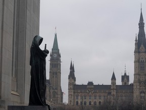 The statue representing justice looks out from the Supreme Court of Canada over the Parliamentary precinct in Ottawa.