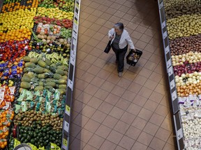 A woman shops inside a Loblaws grocery store, in the produce section.