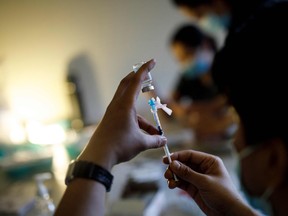 Nurse Kevin Sagun with Humber River Hospital draws a dose of the Moderna Covid-19 vaccine before administering it at a LOFT community housing complex in Toronto, March 26, 2021.