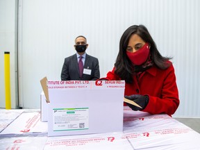 Anita Anand, Canada's Minister of Public Services and Procurement opens a box with some of the first 500,000 of the 2-million AstraZeneca coronavirus disease (COVID-19) vaccine doses that Canada has secured through a deal with the Serum Institute of India in partnership with Verity Pharma at a facility in Milton, Ont., March 3, 2021.