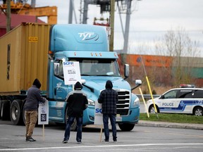 Longshore workers strike outside the Port of Montreal in Montreal on Monday.