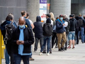 People line up outside a Toronto hospital to receive the COVID-19 vaccine this week.