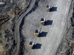 Dump trucks loaded with oilsands drive through a mine in this aerial photograph taken near Fort McMurray, Alberta.