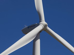 A close-up of a wind turbine against a blue sky.