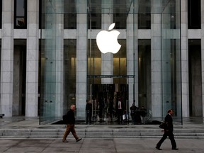 he Apple Inc. logo is seen hanging at the entrance to the Apple store on 5th Avenue in Manhattan, New York.