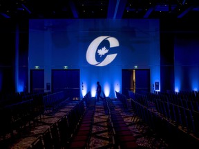 A man is silhouetted walking past a Conservative Party logo before the opening of the Party's national convention in Halifax, in 2018.
