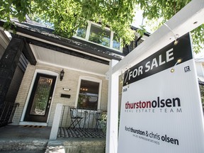 A for sale sign in front of a house in Toronto.