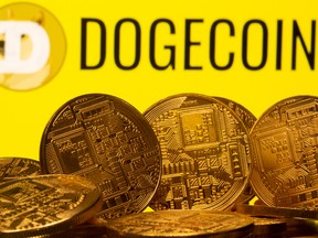 Cryptocurrency representations are seen in front of the Dogecoin logo