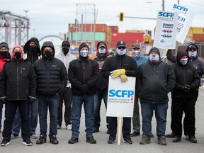 Longshore workers strike outside the Port of Montreal in Montreal, on Monday.