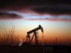 A pumpjack in a field at sunset