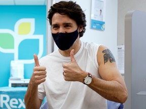 Prime Minister Justin Trudeau reacts after being inoculated with AstraZeneca's vaccine against COVID-19 on Friday.