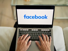 he logo for Facebook is displayed on a laptop computer