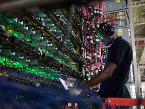 A technician monitors cryptocurrency mining rigs at a Bitfarms facility in Saint-Hyacinthe, Quebec, Canada.