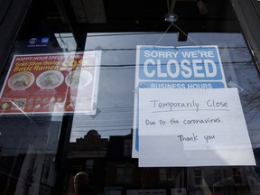 A closed sign is displayed on the door of a restaurant in Toronto during the coronavirus pandemic. Women and younger workers are feeling the brunt of job losses because they tend to dominate the industries that have been effectively closed for much of the past year.