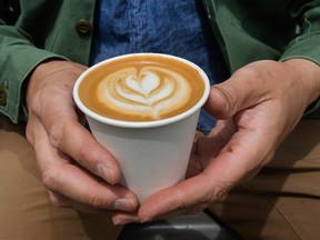 Wallace Espresso founder and owner Daniel Wahlen shows an oat milk cappuccino at his Toronto cafe.