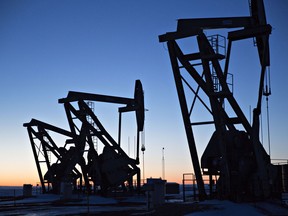 The silhouettes of pumpjacks are seen above oil wells in the Bakken Formation near Dickinson, North Dakota. To meet climate goals, the role of fossil fuels should reverse entirely from 80 per cent of global energy needs today to barely a fifth by mid-century, says the IEA.