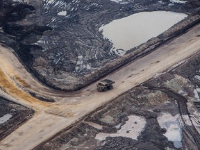 A heavy hauler truck drives through the Suncor Energy Inc. Millennium mine in this aerial photograph taken above the Athabasca oilsands near Fort McMurray.