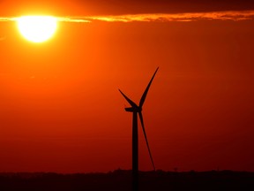 The sun rises behind a wind turbine in Belgium.