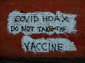 Anti-vaccine graffiti spray-painted on a wall.