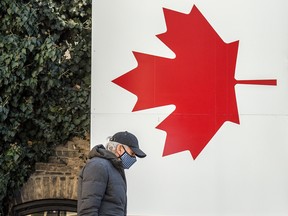 A pedestrian walks by a painted Canadian flag in Toronto.