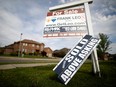 A real estate sign that reads "For Sale" and "Sold Above Asking" stands in front of housing in Vaughan, a suburb in Toronto.