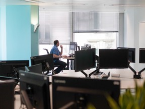 An employee works at a computer inside an office.