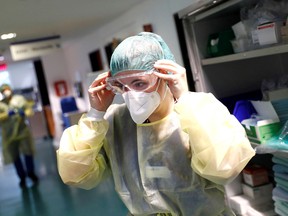 A nurse adjusts her PPE at a hospital in Germany.