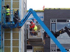 Construction workers work on a new apartment building in Ottawa. Housing spending grew at an annualized 43 per cent pace.
