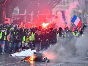 TOPSHOT - Protesters wearing yellow vests (gilets jaunes) set up a barricade during a demonstration against rising costs of living they blame on high taxes in Bordeaux, south-western France, on December 15, 2018. - The "Yellow Vests" (Gilets Jaunes) movement in France originally started as a protest about planned fuel hikes but has morphed into a mass protest against President's policies and top-down style of governing. (Photo by GEORGES GOBET / AFP)GEORGES GOBET/AFP/Getty Images