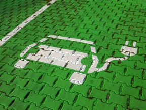 An electric car stencil symbol sits on a parking space at an electric vehicle charging site