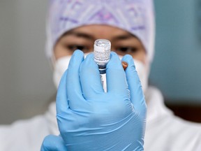 A health-care worker prepares a dose of the Pfizer/BioNTech vaccine in Ecuador.