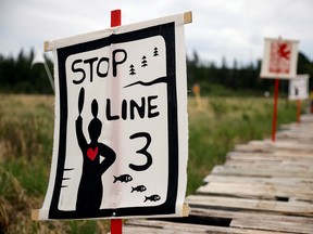 Protest signage on display at a camp established by Indigenous leaders and water protectors at the Mississippi headwaters, one body of water the Line 3 pipeline will cross in Solway, Minnesota, U.S., June 8, 2021.
