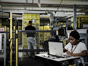 mployees are seen on duty at work stations part of mobile robotic fulfilment systems also known as 'Amazon robotics' during the inauguration of a new Amazon warehouse in France.