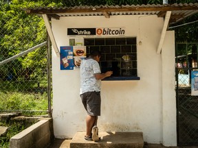 A person purchases a bottle of Coca-Cola from a shop that accepts Bitcoin in El Zonte, El Salvador.