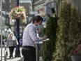 A server take orders from customers at the outdoor dining area of a restaurant in downtown Toronto.