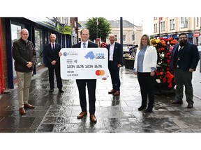 Pictured in Carrickfergus, County Antrim: Far left, Lee Britton, CEO Europe at EML, centre with card, Gordon Lyons, Northern Ireland's Minister for the Economy, and second from right, Sarah Cunningham, Vice President and Lead at Mastercard's Dublin Technology Hub.