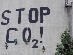 Greenpeace activists paint a slogan reading "Stop CO2" on one of the smoke stacks at the Belchatow power plant in Rogowiec, Poland. The world as a whole isn’t great at providing global public goods, like emission reduction, writes William Watson.