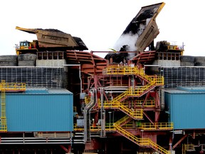 Heavy hauler trucks unload into a crusher at the Fort Hills oilsands project.