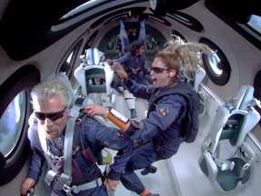 Billionaire Richard Branson and crew members Beth Moses and Sirisha Bandla float in zero gravity on board Virgin Galactic's passenger rocket plane VSS Unity after reaching the edge of space Sunday.