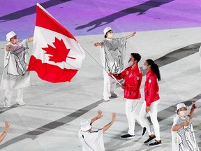 Team Canada flag-bearers carry the Canadian flag at the opening ceremonies during the Tokyo Olympics on July 23, 2021.