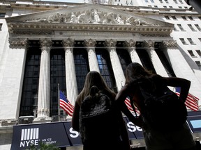 Members of a tour group look at the front facade of the New York Stock Exchange (NYSE) in New York City.
