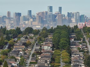 Single family homes are seen against the skyline of Vancouver.